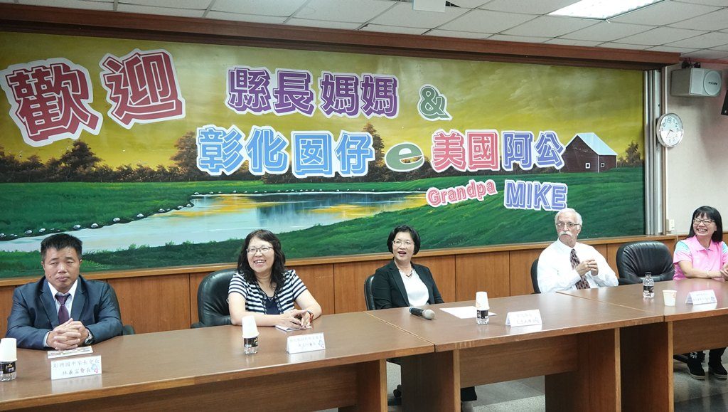 Magistrate Wang, a Changhua child, and 'Grandpa Mike' share a table