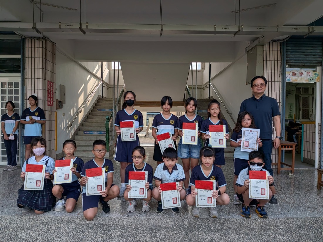 獲獎學生手持獎狀於川堂合影 · Award-winning students with their certificates in the school hallway