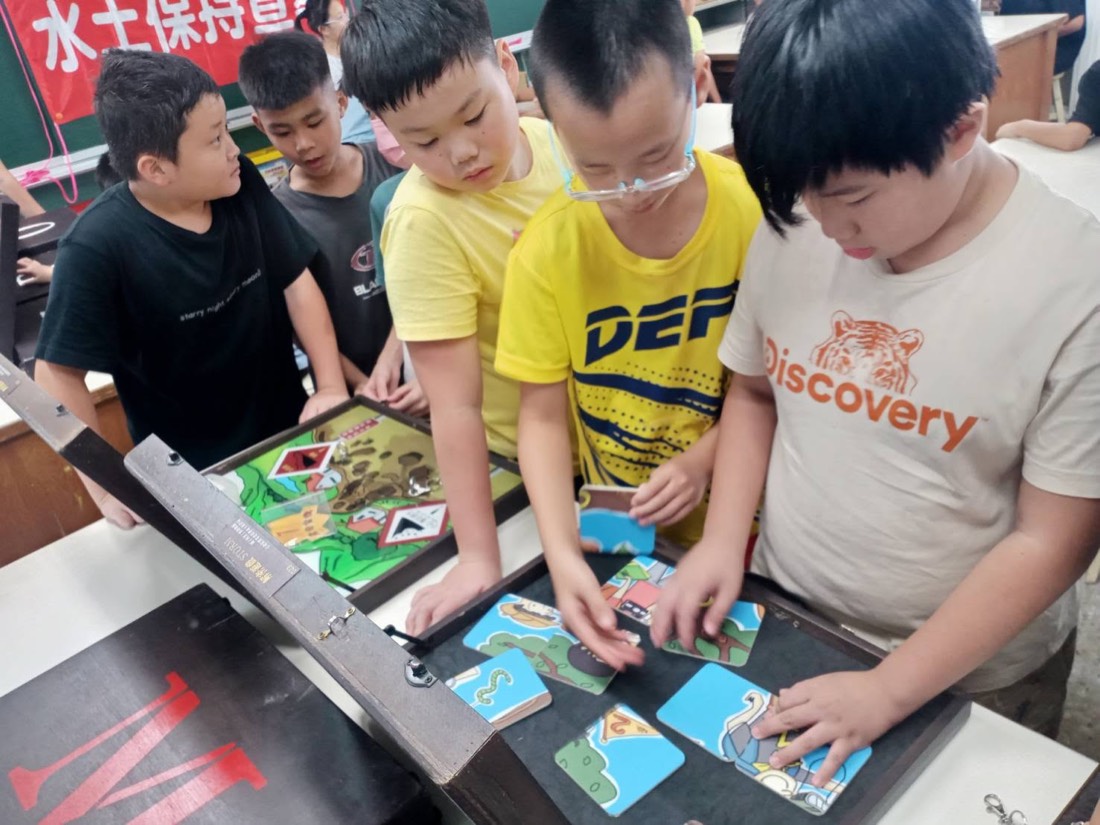 學生動手操作水保防災行動教具 · Students work through the soil and water conservation teaching kit