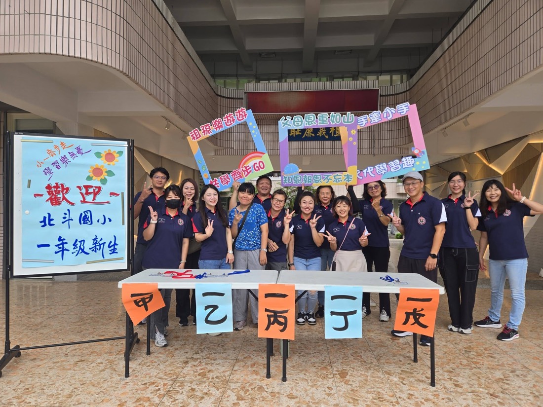 志工團隊在「歡迎北斗國小一年級新生」看板前合影 · The volunteer team gathers at the welcome sign for new first graders
