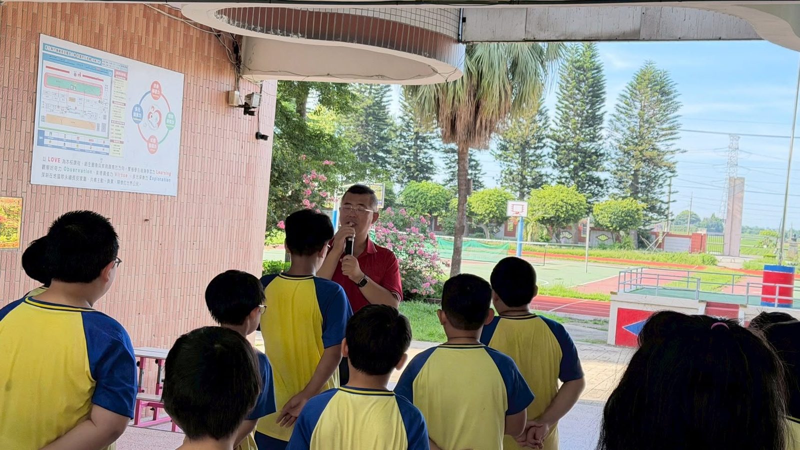 The principal speaking to students at the outdoor closing ceremony