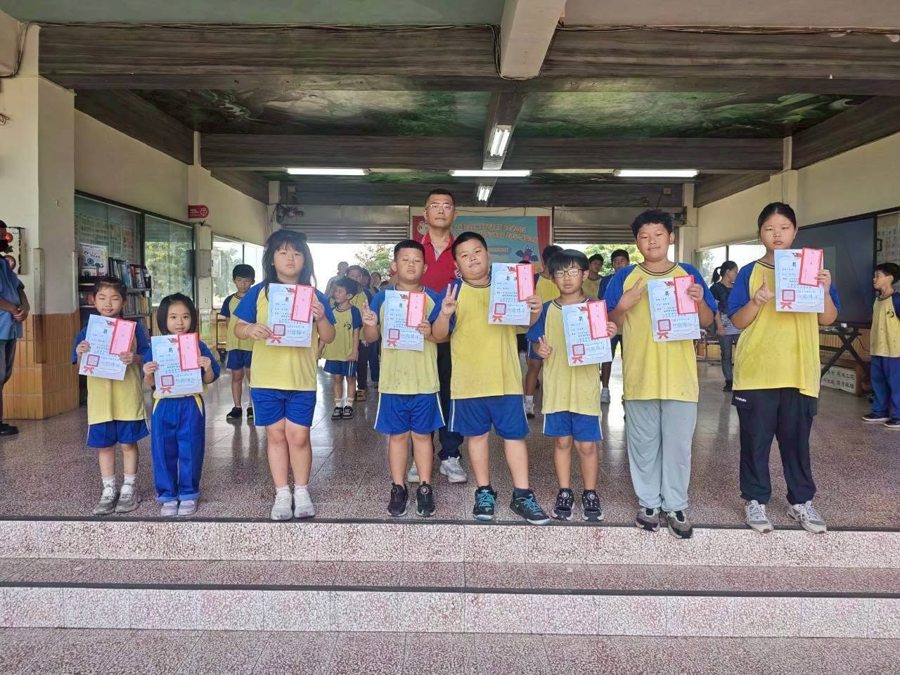 Students holding certificates with the principal at the closing ceremony