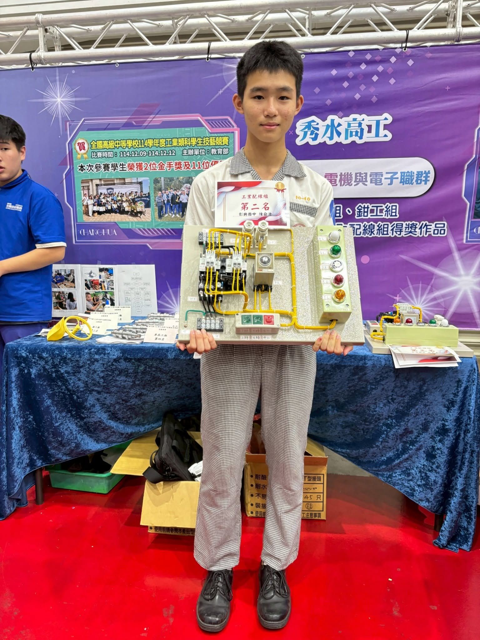 Changsing student holding his award-winning industrial wiring control panel 彰興國中學生工業配線競賽作品