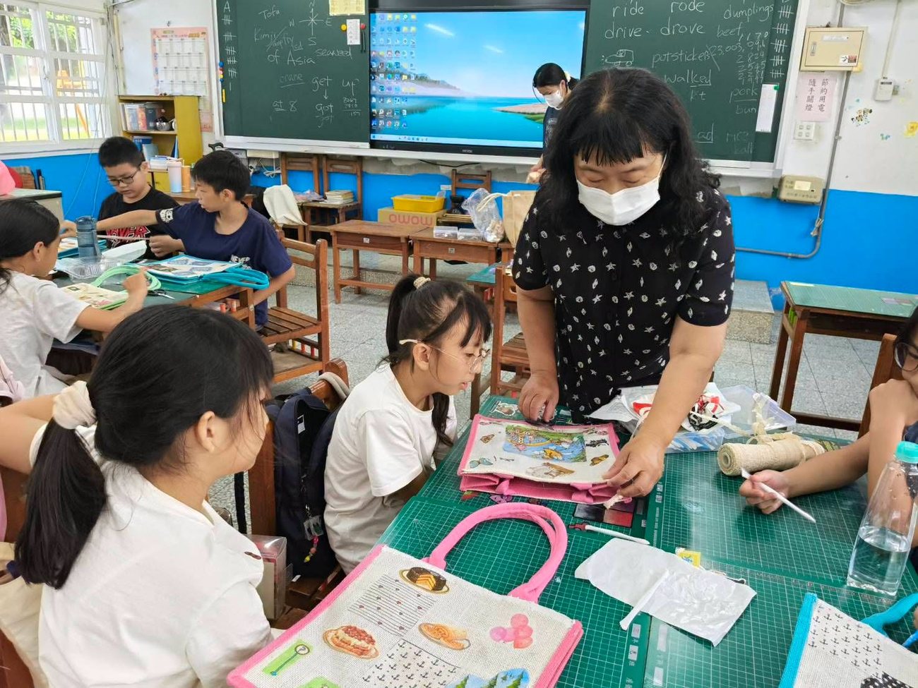 朝興國小學生在夏日樂學課堂上,由老師指導製作蝶古巴特提袋
