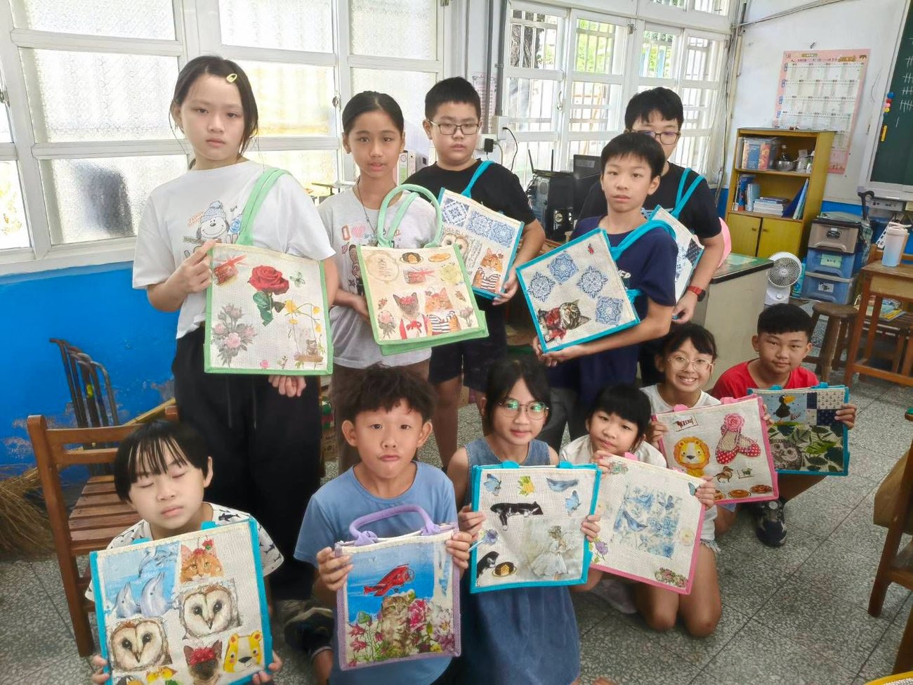 朝興國小學生開心舉起自己完成的蝶古巴特拼貼提袋作品