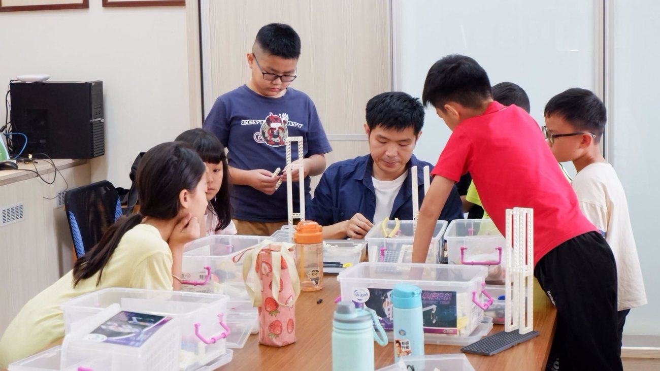 朝興國小學生在夏日樂學「機關王」課程中，由講師帶著組裝結構零件