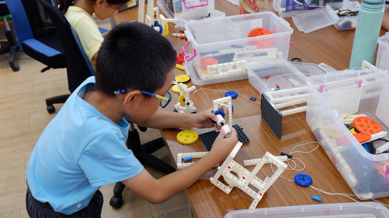 朝興國小學生專注地將齒輪與積木零件組裝成機關結構