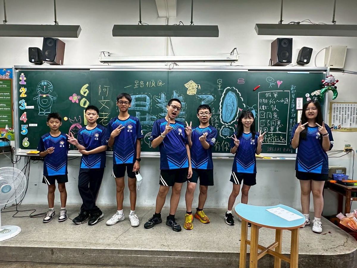 畢業生在黑板前合影比手勢