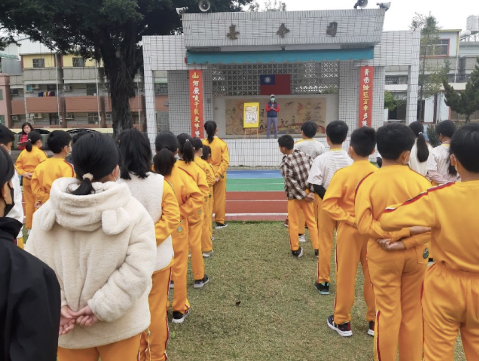 老師在校園以海報向學生宣導登革熱防疫四步驟