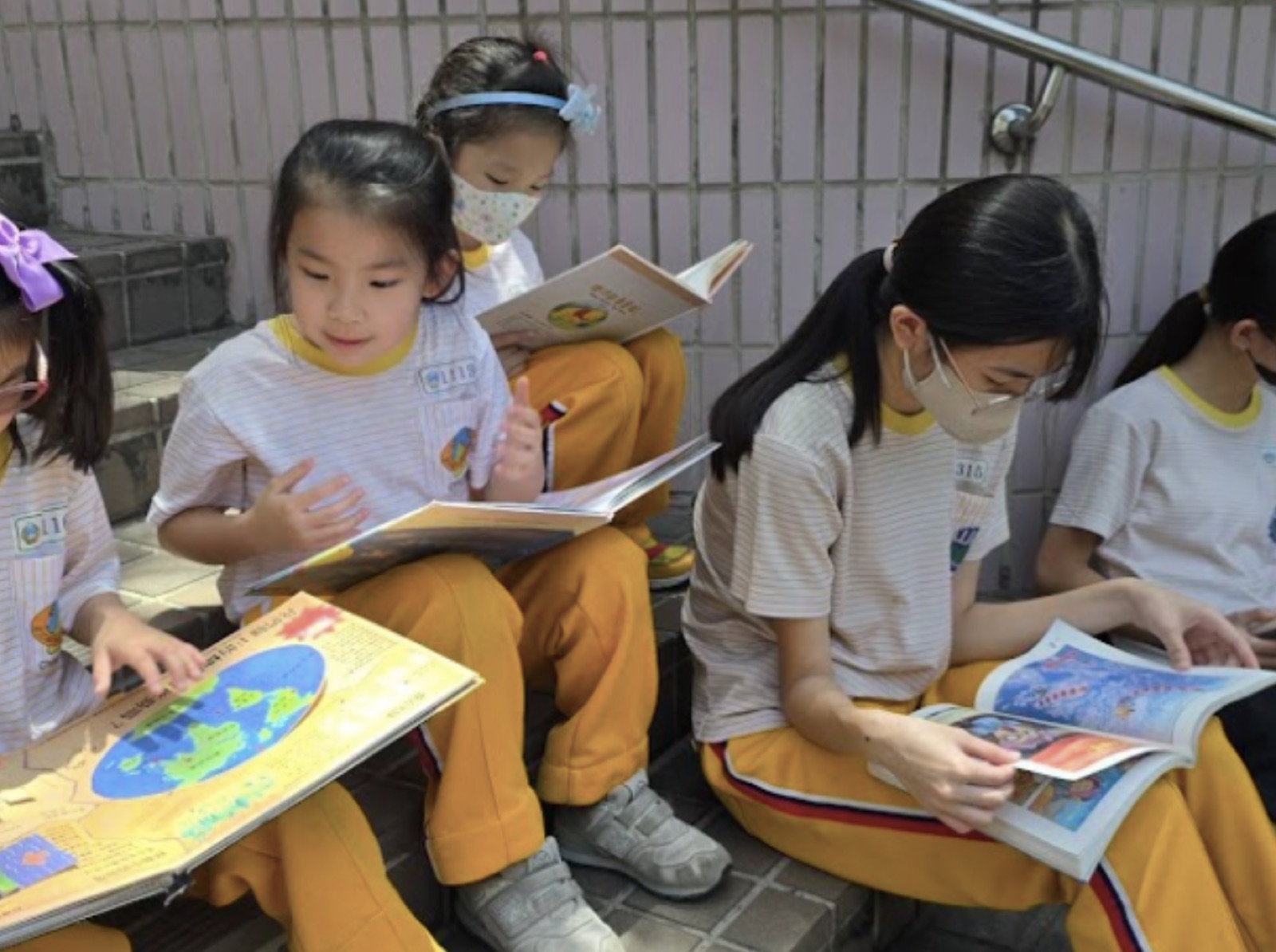 學生們坐在階梯上專心閱讀雲水書車帶來的書籍