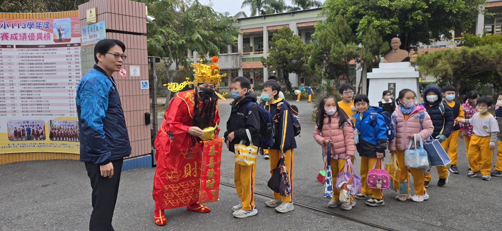 財神爺在校門口向青山國小學生賀年
