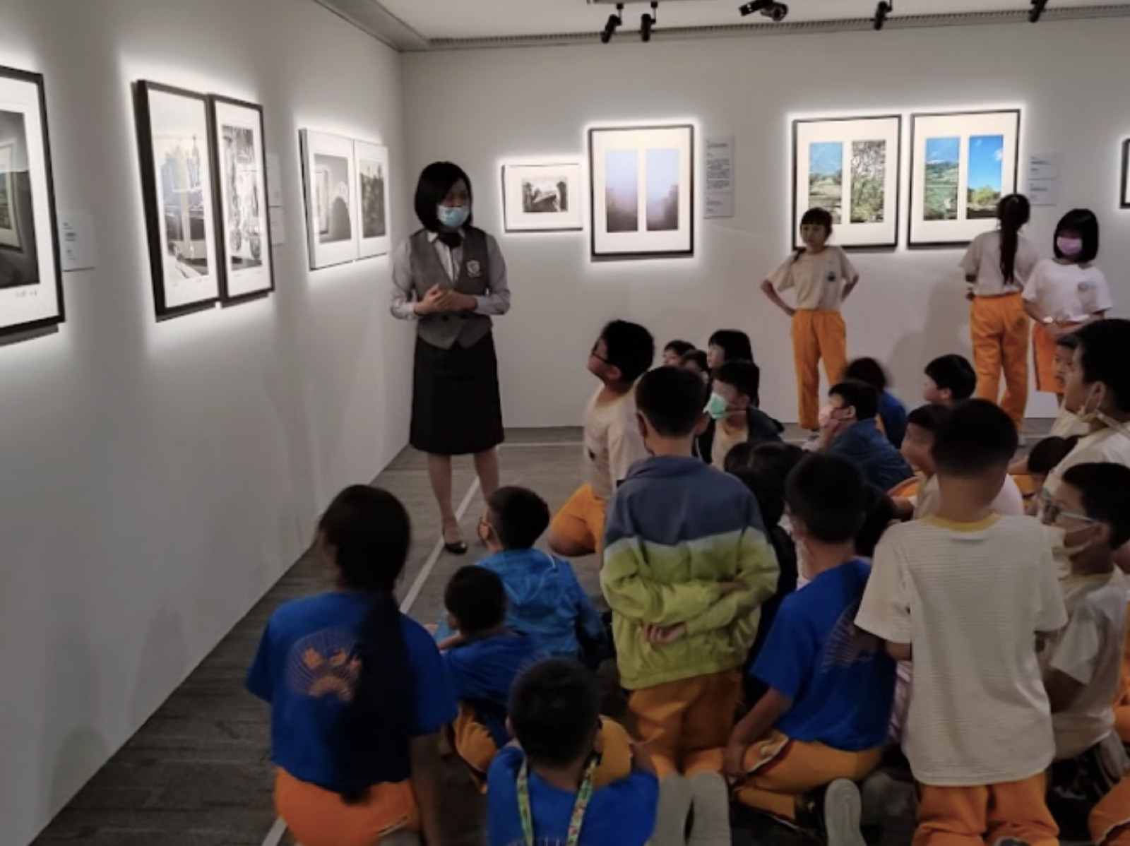 美術館導覽人員向學生介紹攝影作品