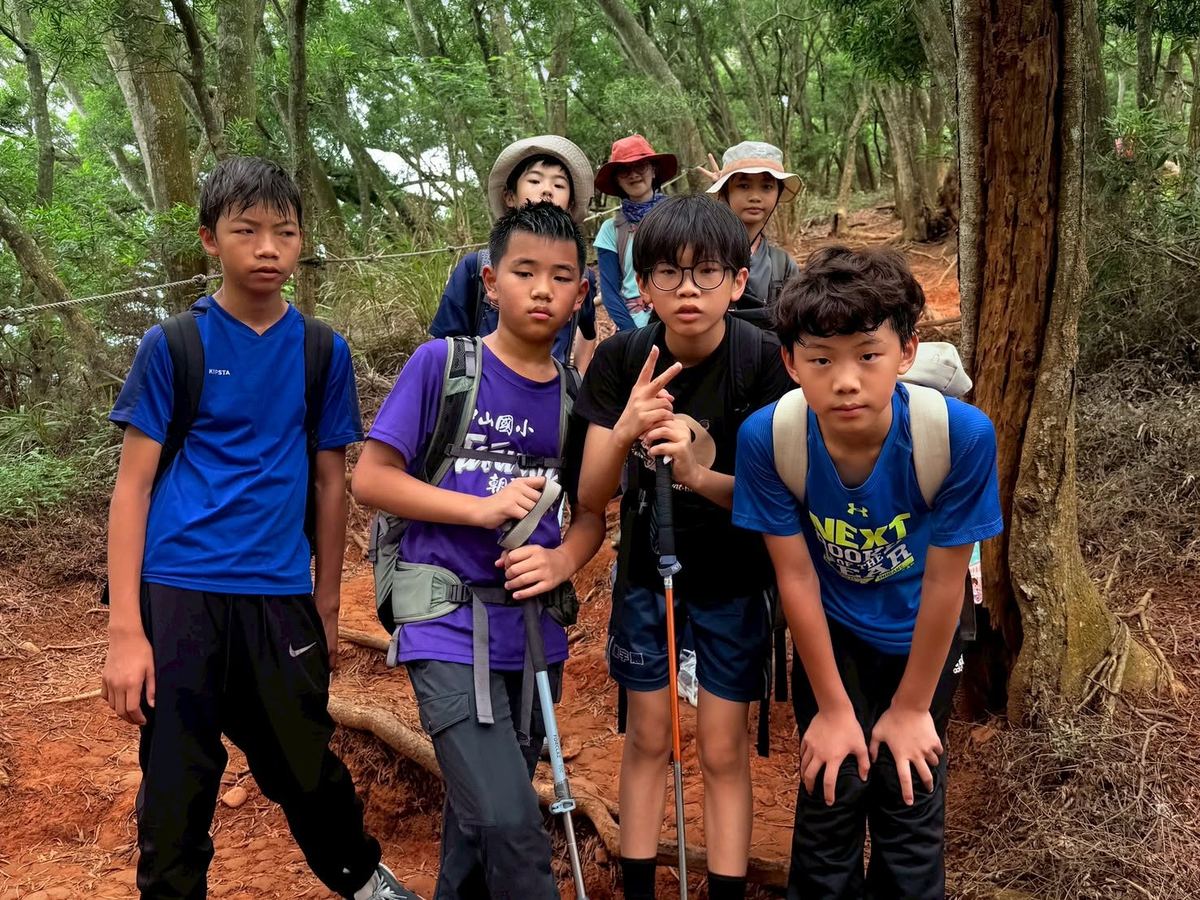 學生們在山徑上休息比手勢