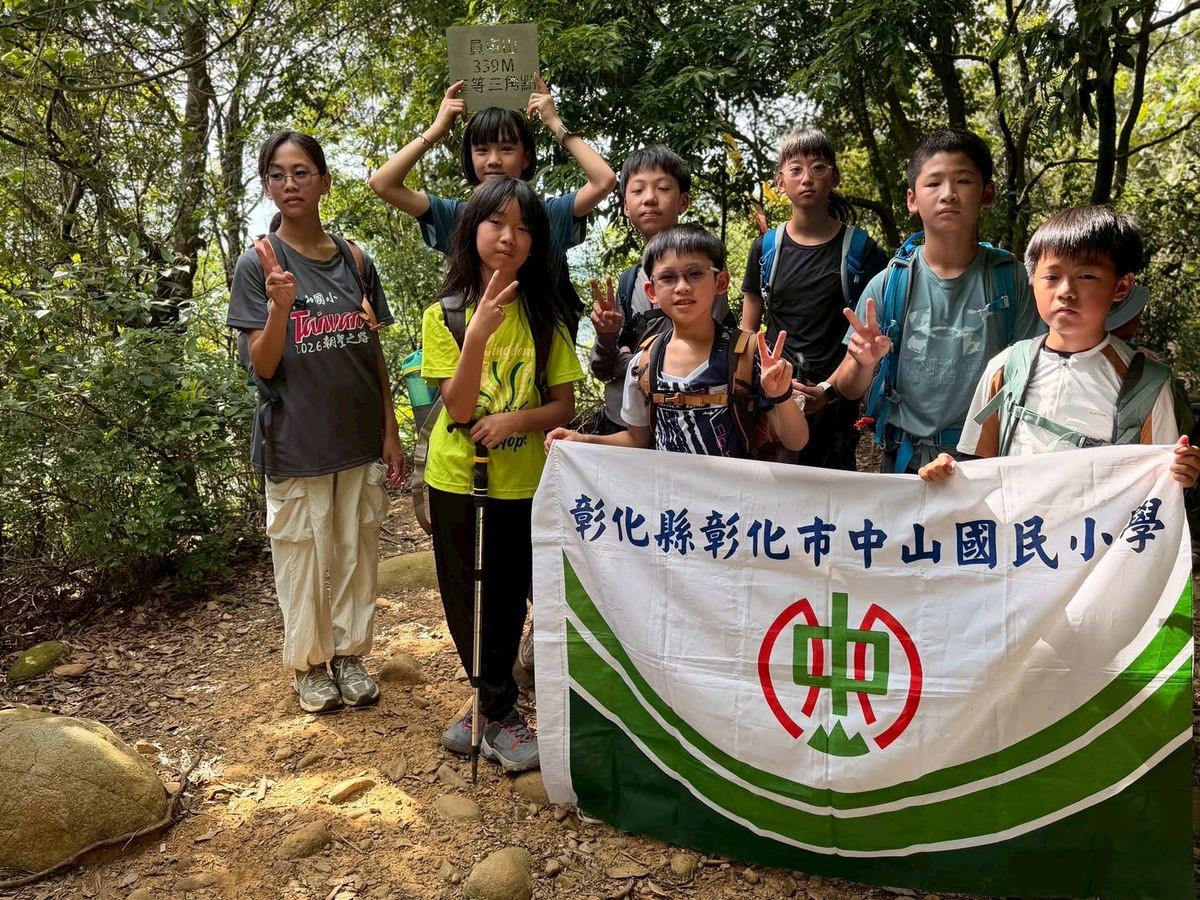 孩子們在貴富山339公尺三角點與校旗合影