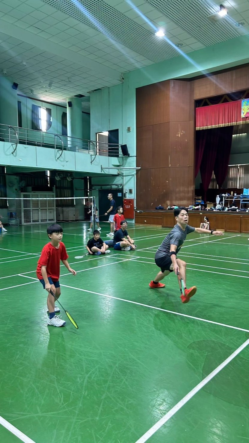 爸爸與兒子搭檔雙打，對手在旁休息觀戰