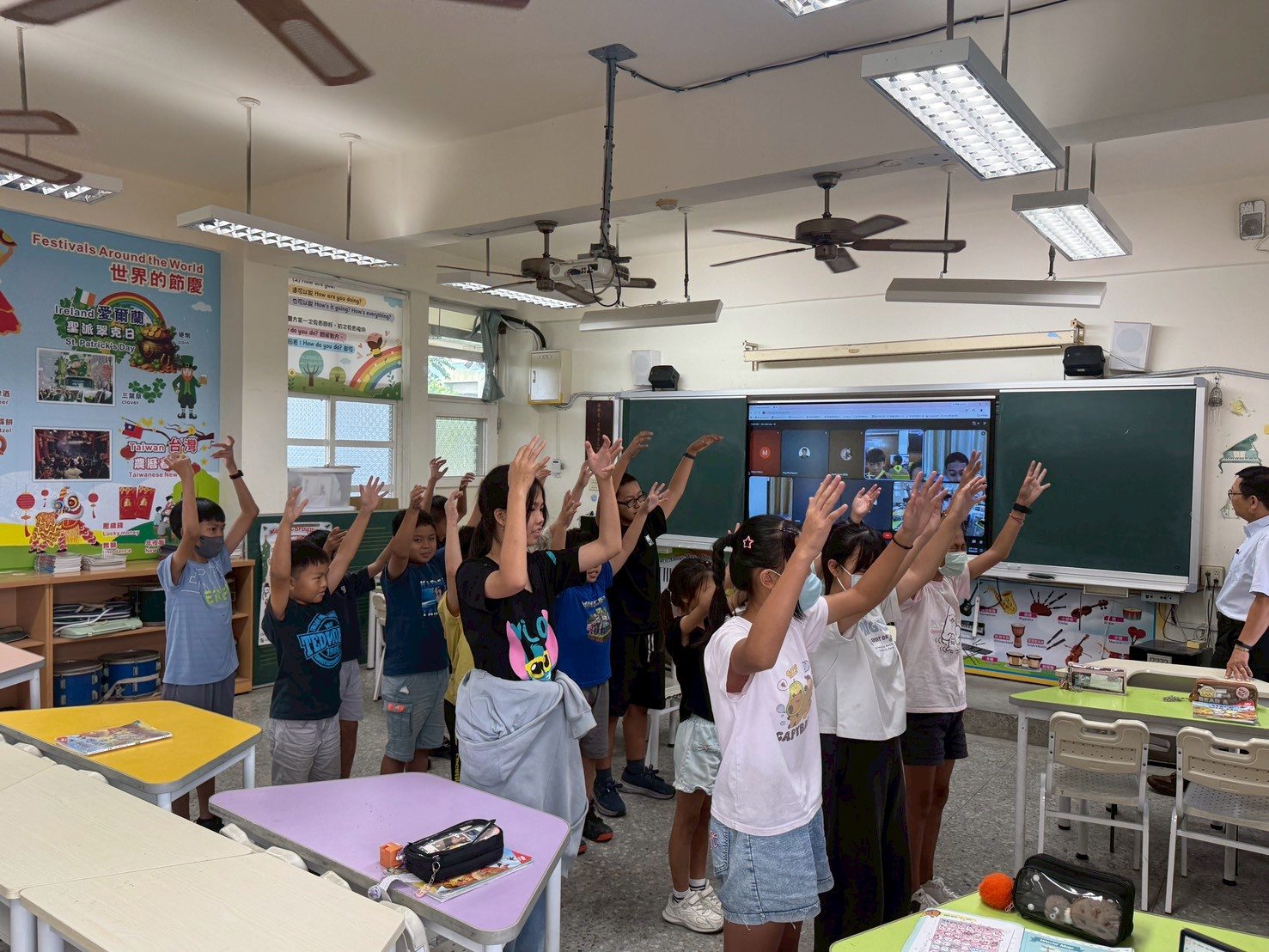 Cundong students perform an action song for their Thai partner class in front of the classroom screen