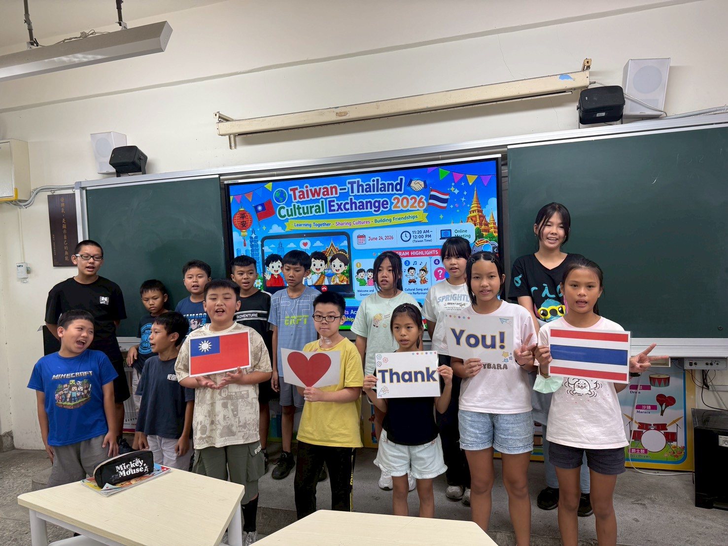 Cundong students hold up Thank You signs with the Taiwan and Thailand flags at the end of the video call