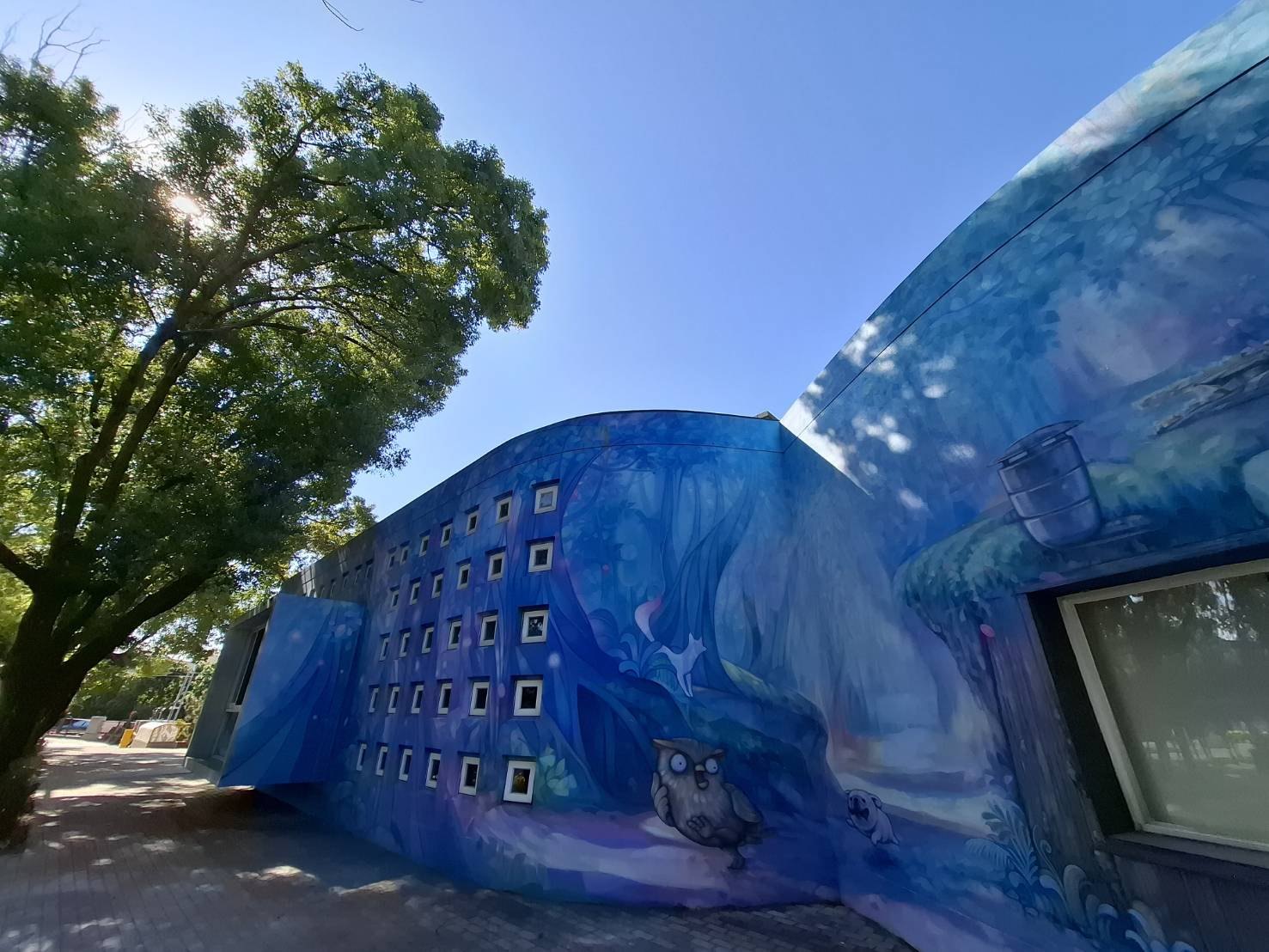 Cundong's library — a blue forest-and-owl mural wrapping the building