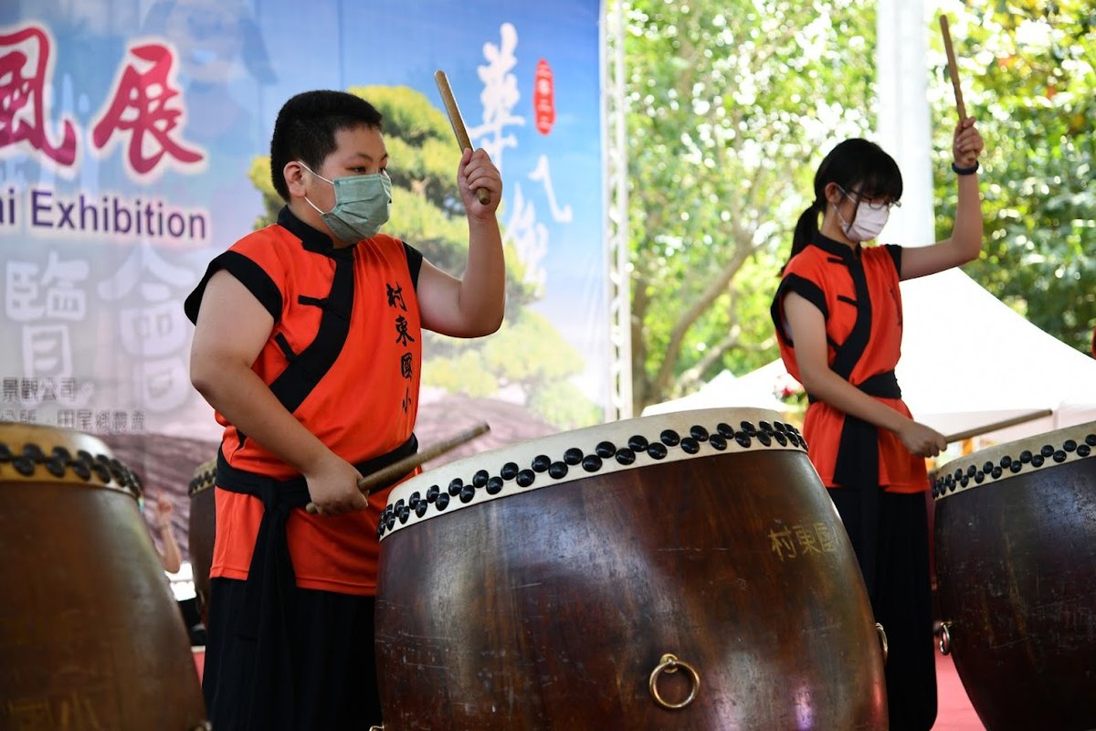 Cundong Ten Drum students in orange uniforms performing