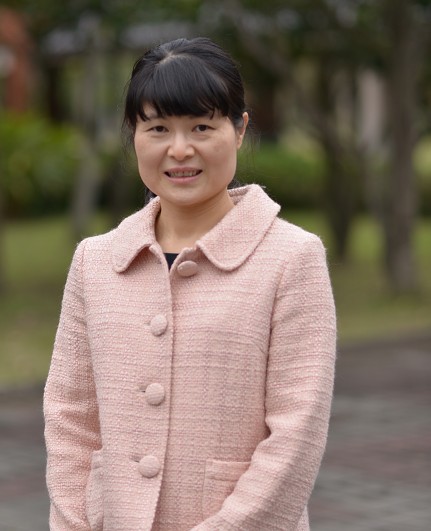 王明雅校長,在校園的綠樹步道前 · Principal Wang Ming-ya of Da Jah Elementary School, standing on a tree-lined campus path