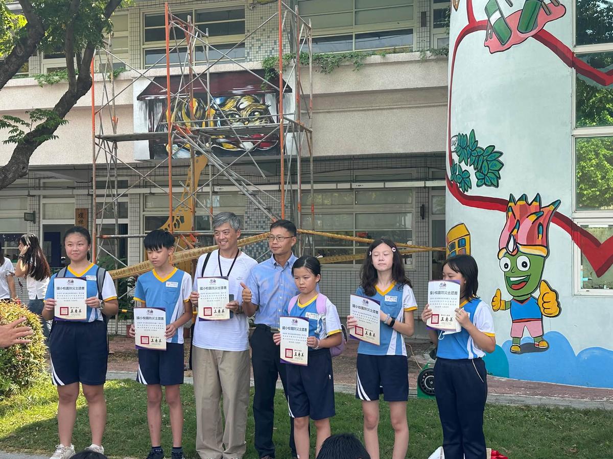 Young disaster scouts hold up their certificates after finishing the challenge stations.