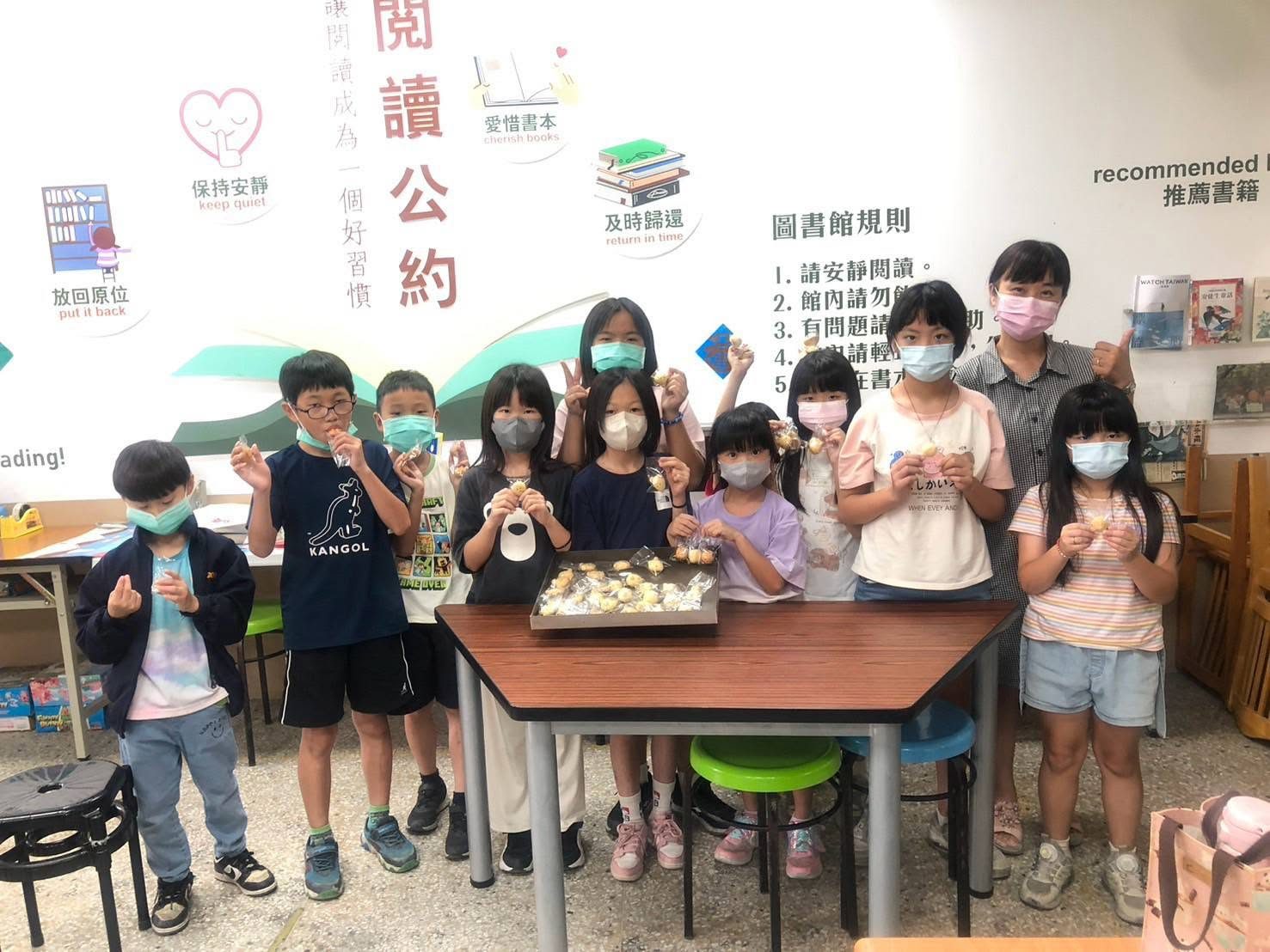 大園國小學生手拿甜點在圖書館合影