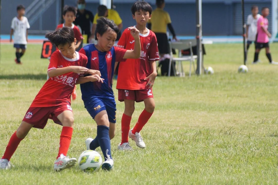 A Dacheng player shielding the ball from two opponents