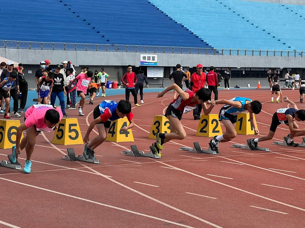Sprinters leaving the starting blocks at the county athletics meet