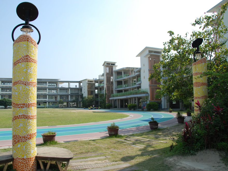 Mosaic-tiled lamp posts beside the colored running lanes