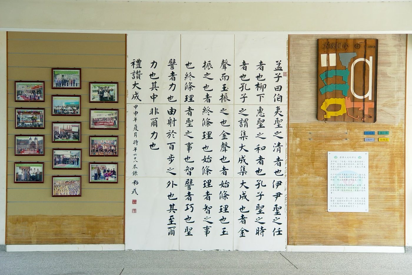 A corridor wall of calligraphy beside the school's wooden crest board