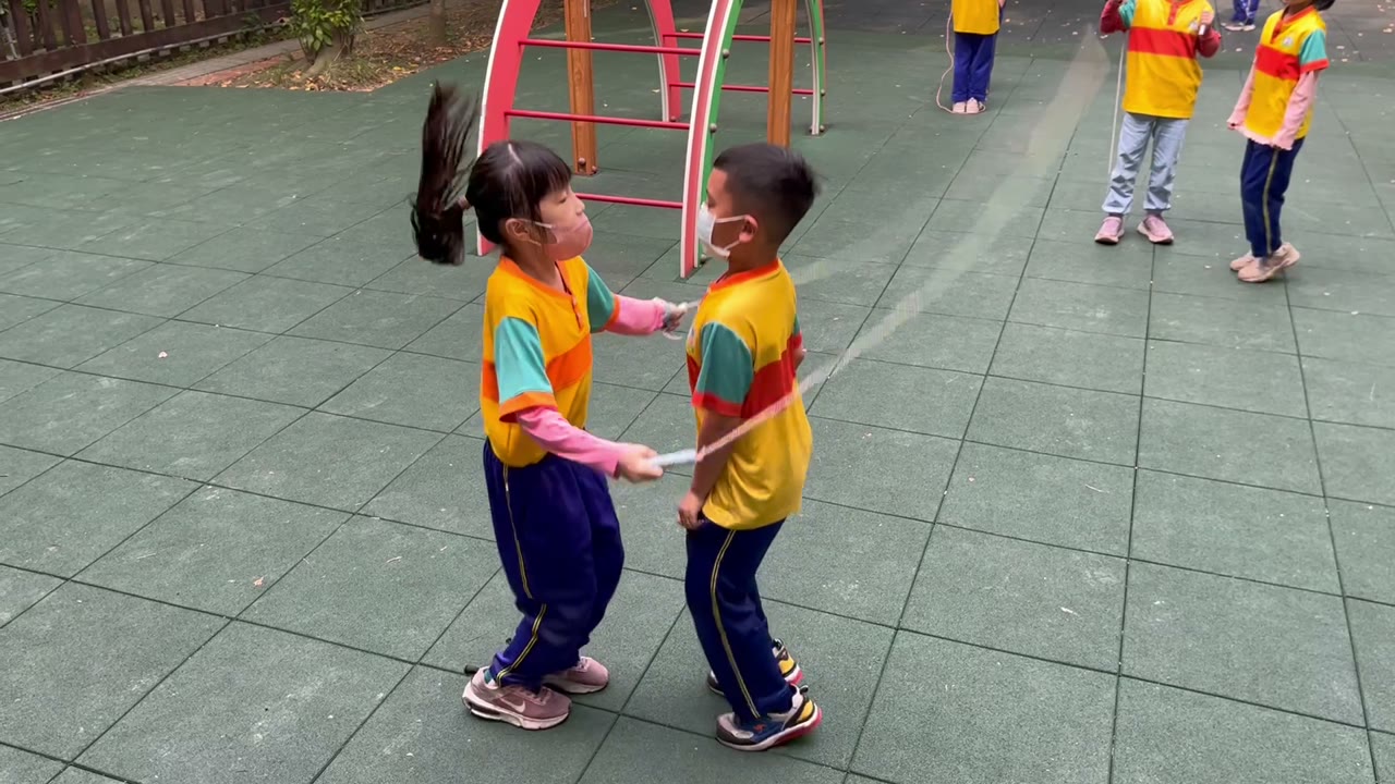 Two classmates practicing with jump ropes on the playground
