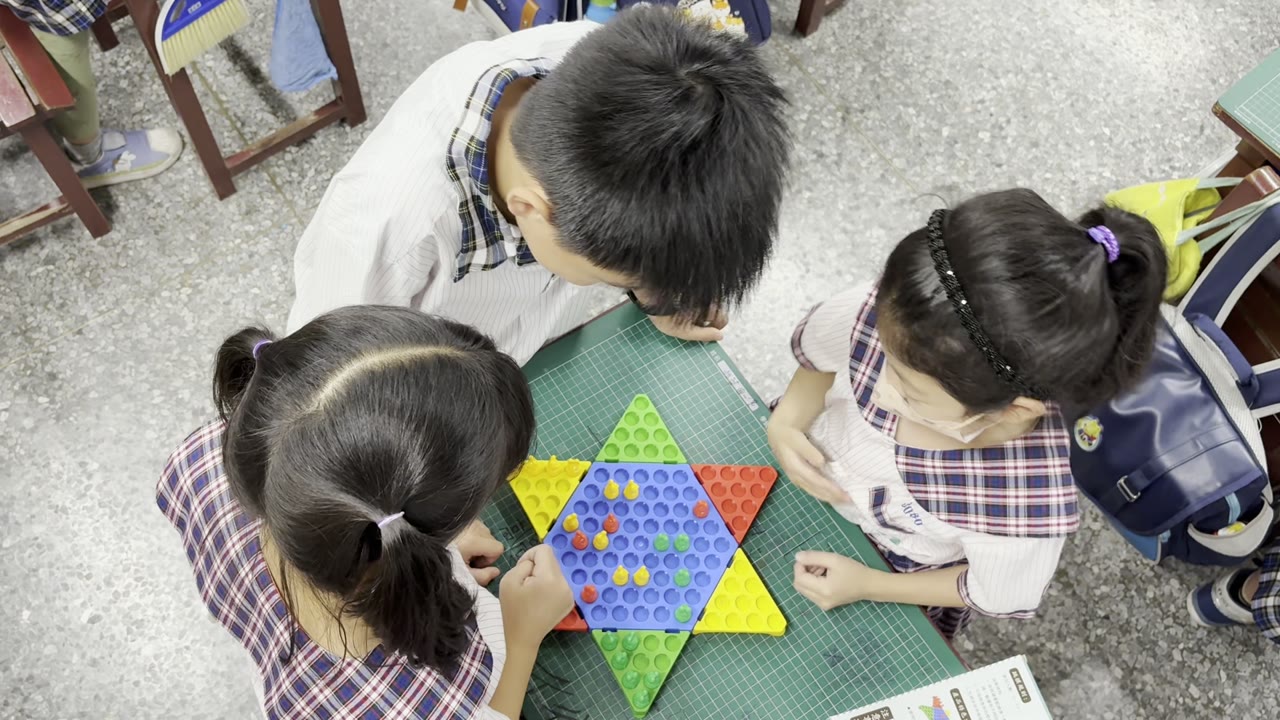 Students playing Chinese checkers on a star-shaped board