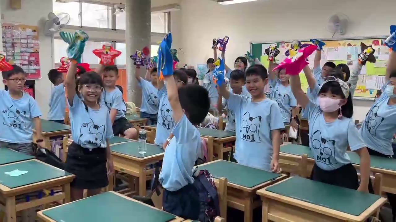 Students holding up the colorful paper eagles they made