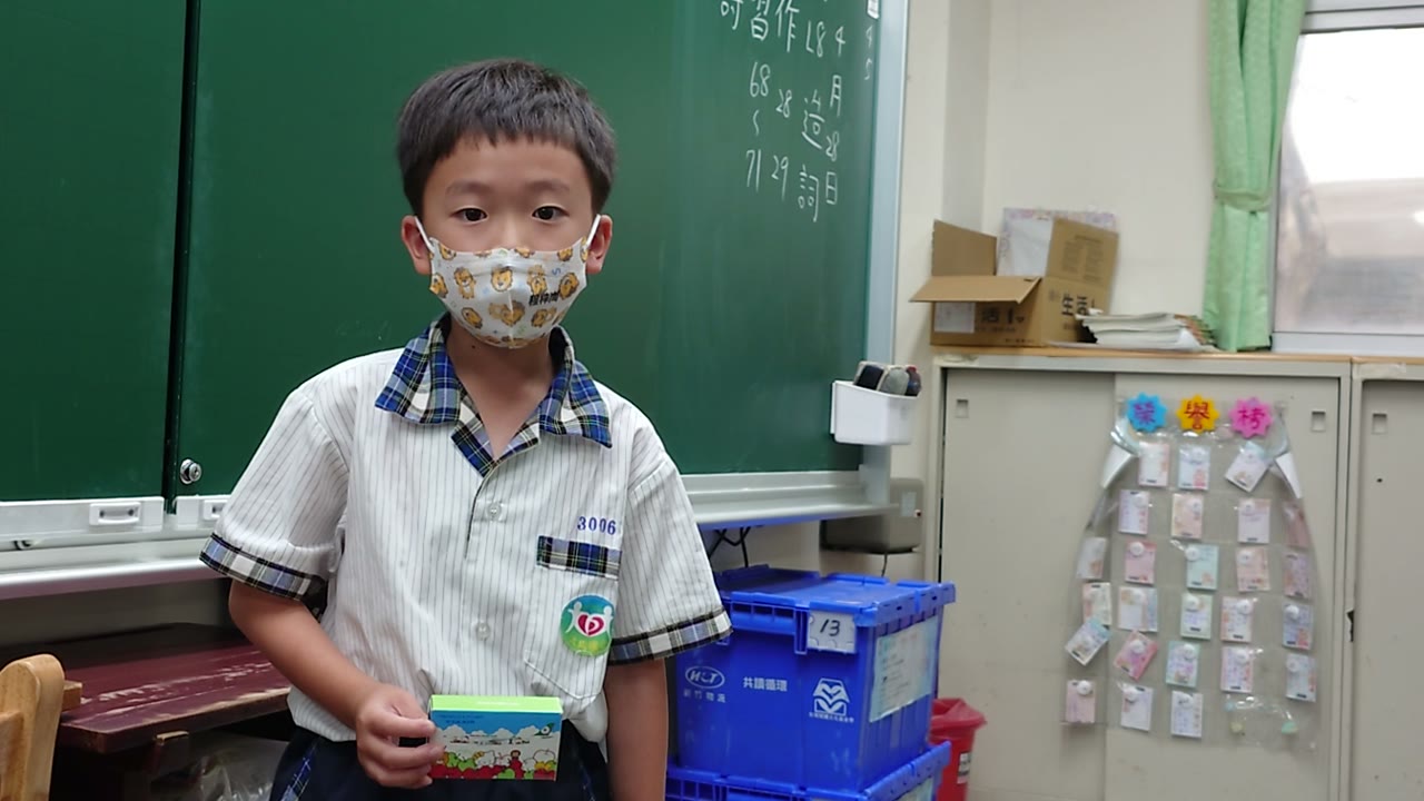 A first grader stands at the front of the class holding his favorite toy