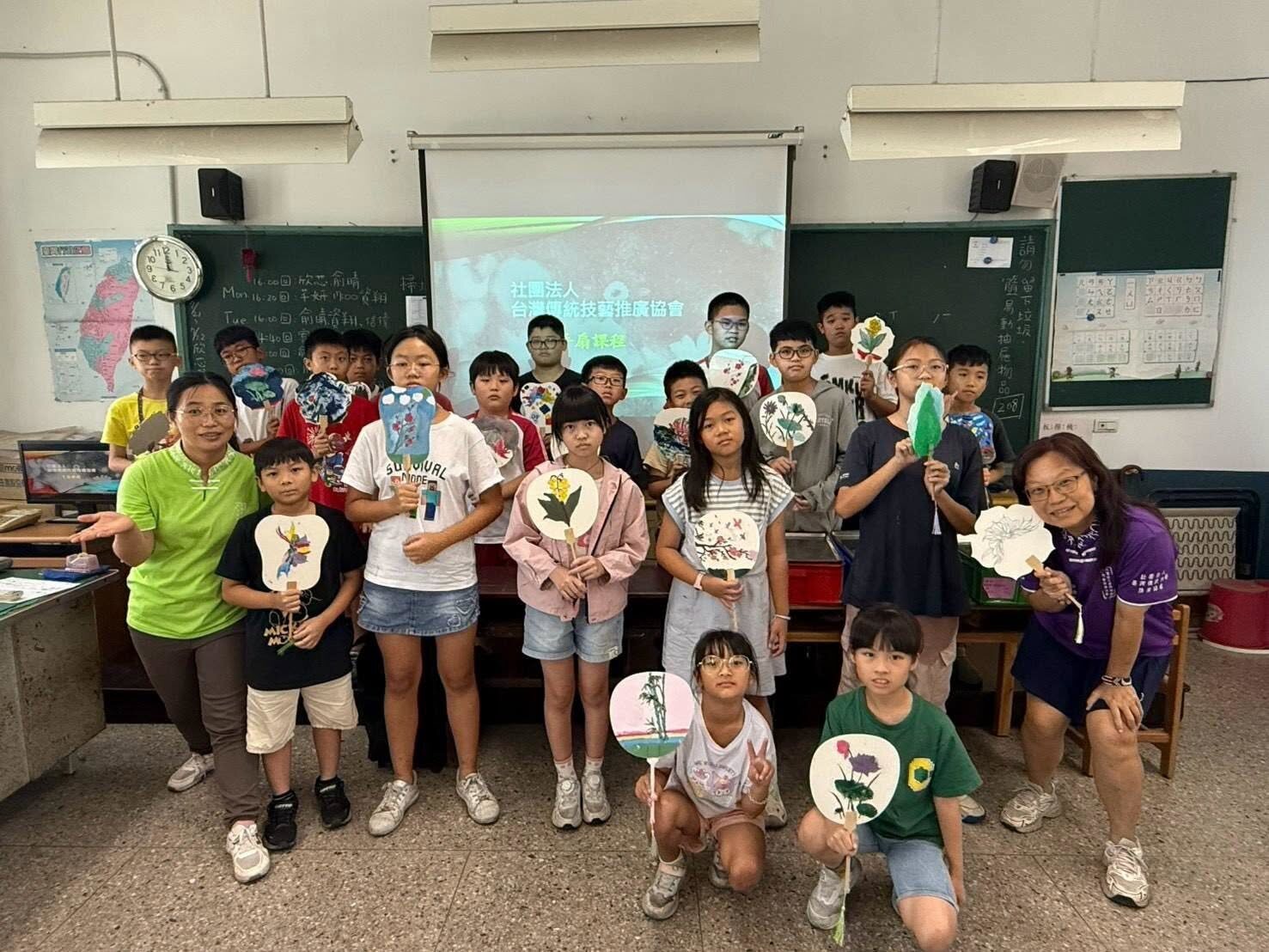 Dongshing students holding hand-painted fans from local language camp