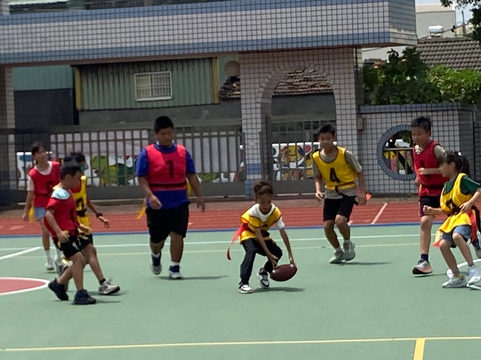 Dongshing students playing flag football during summer camp