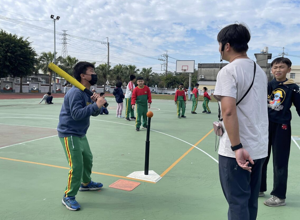 A Dongshing student swinging a tee-ball bat