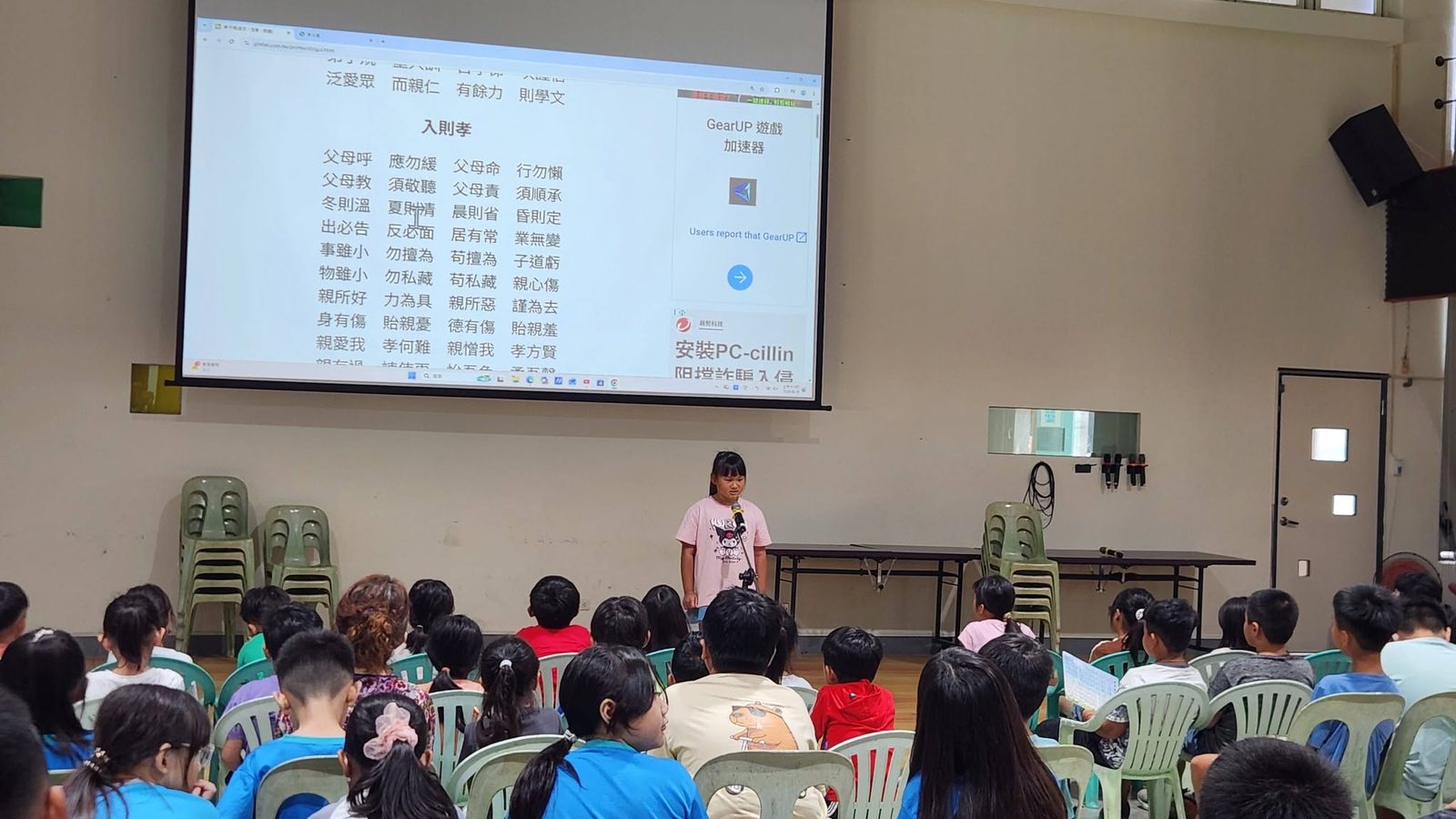 A student reciting on stage in front of classmates