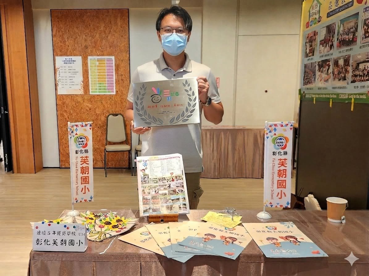 A Fuchao Elementary staff member holding the school's Three Good Campus award plaque
