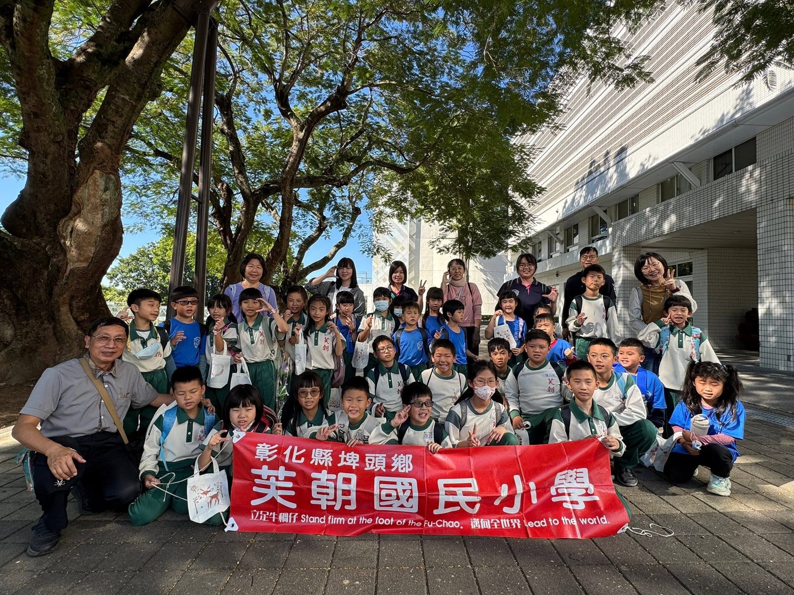 A Fuchao Elementary class on a field trip holding the school banner