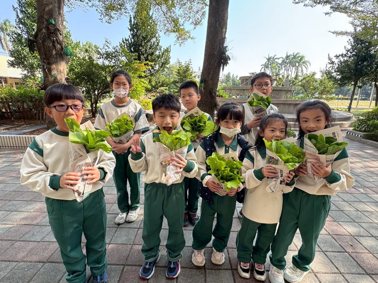 Fuchao Elementary students holding freshly picked vegetables