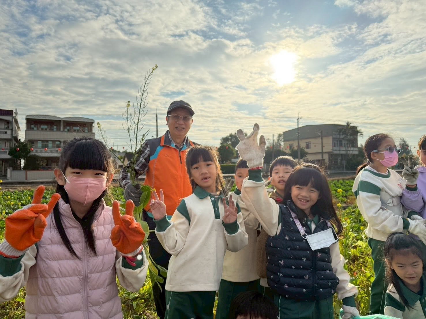 Principal Chou working alongside students in the school garden at sunrise