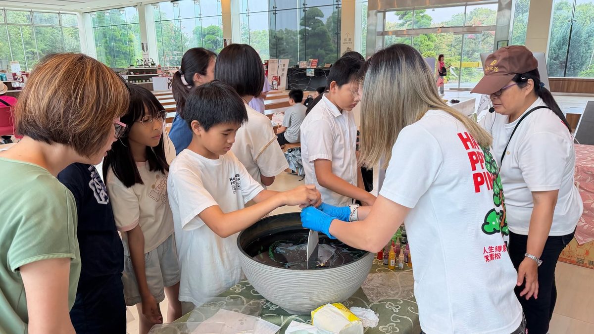 Students trying indigo dyeing in a traditional vat at Chengmei