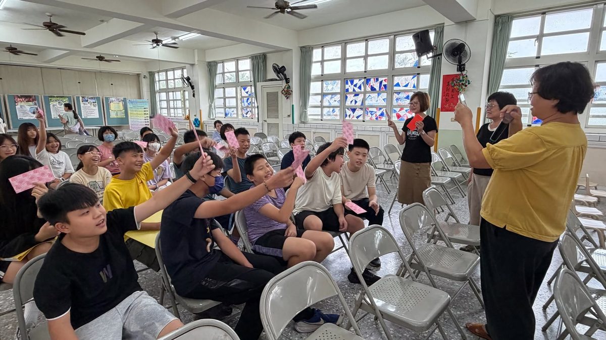 Students rehearsing in the auditorium guided by their teacher