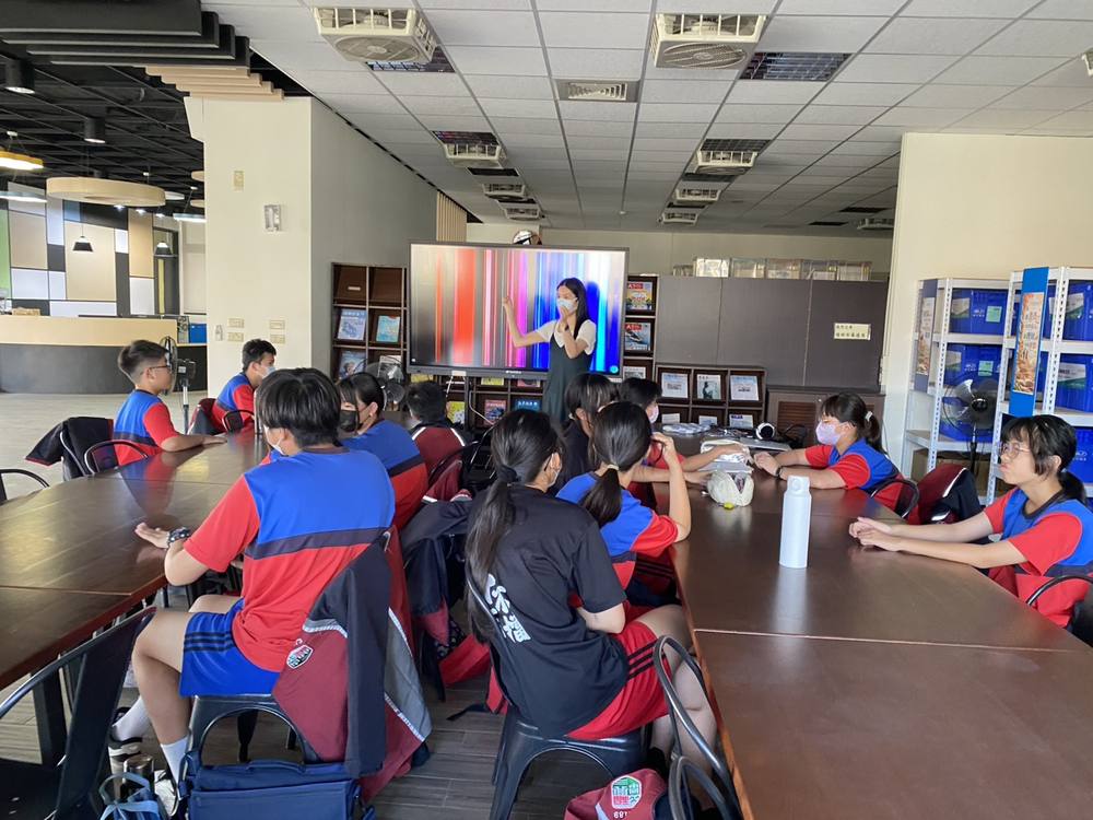 Students in the English Drama Club watch a teacher demonstrate in front of a large screen