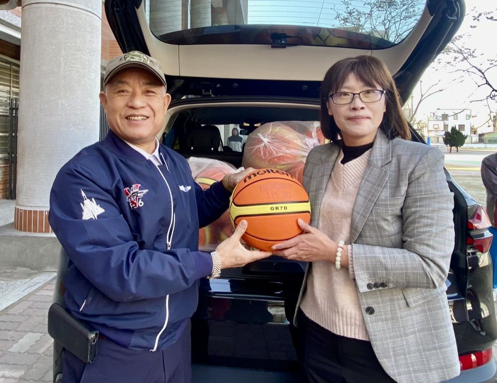 Close-up of the donation handoff of a Molten basketball