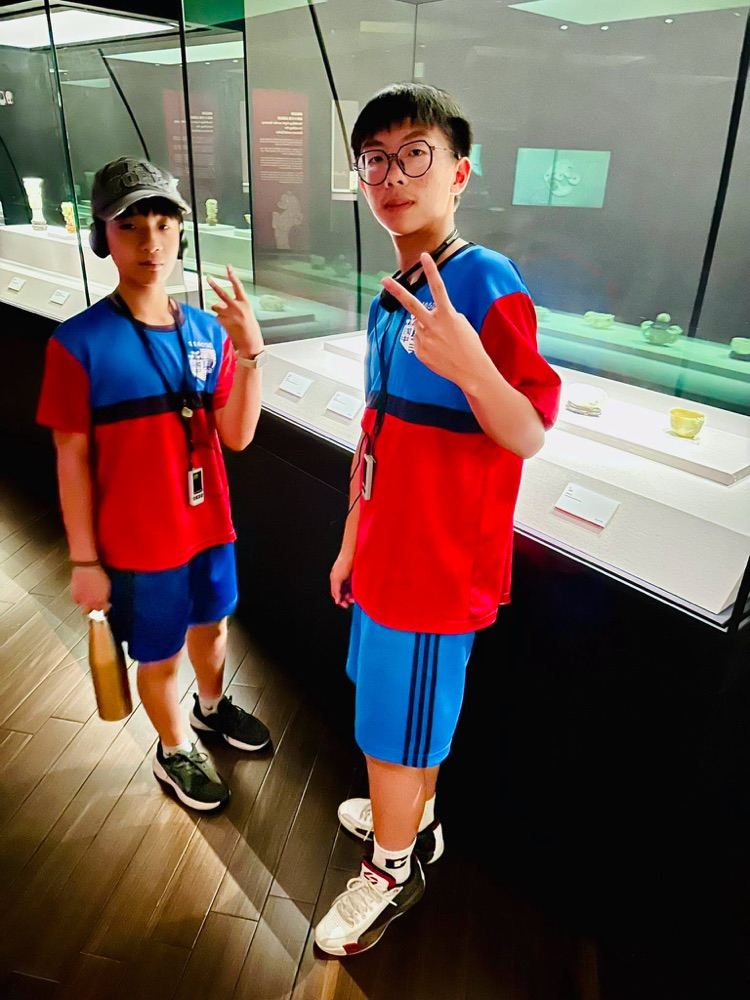 Two students posing with audio guide devices in the exhibit hall