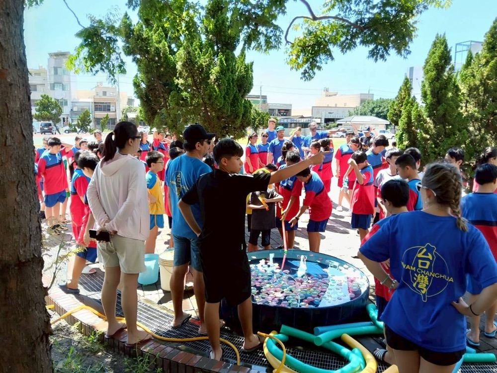 A crowd of students gathered around a balloon pool for an outdoor water game