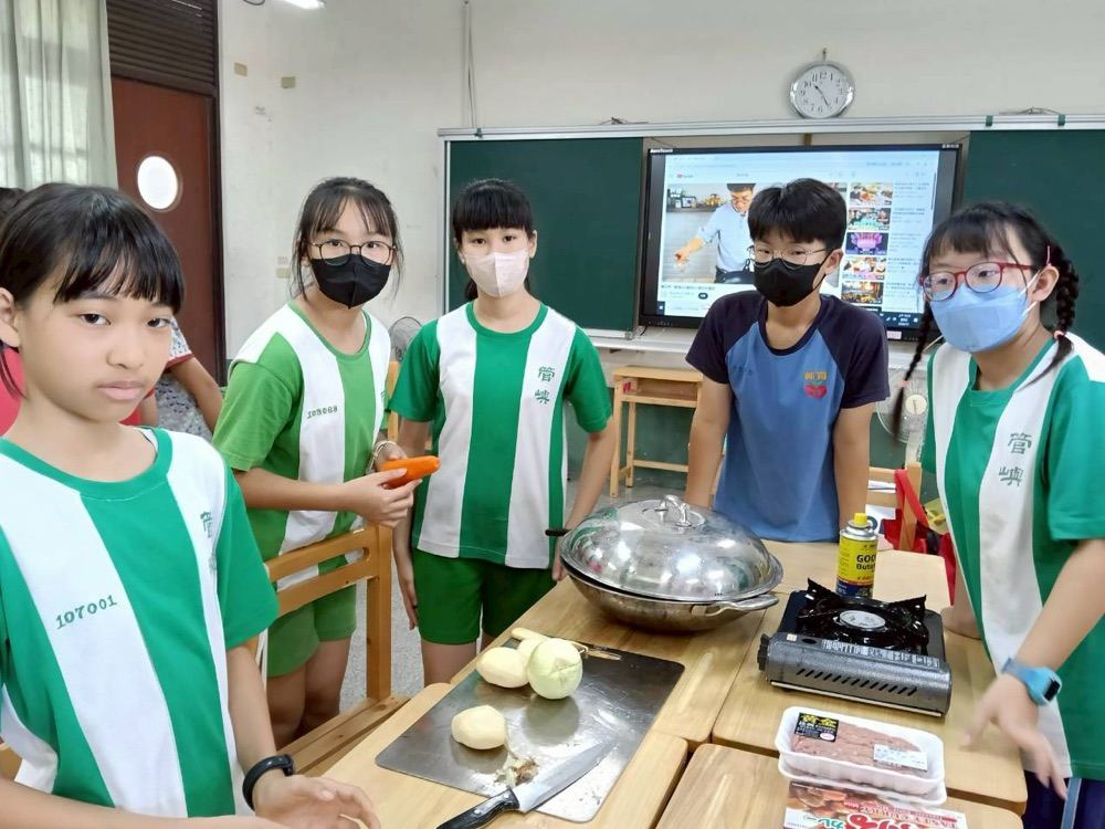 Students chopping vegetables at a sink during the cooking activity