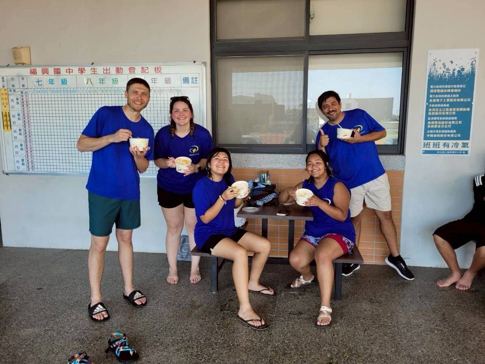 Foreign teacher volunteers sharing a meal together during a break